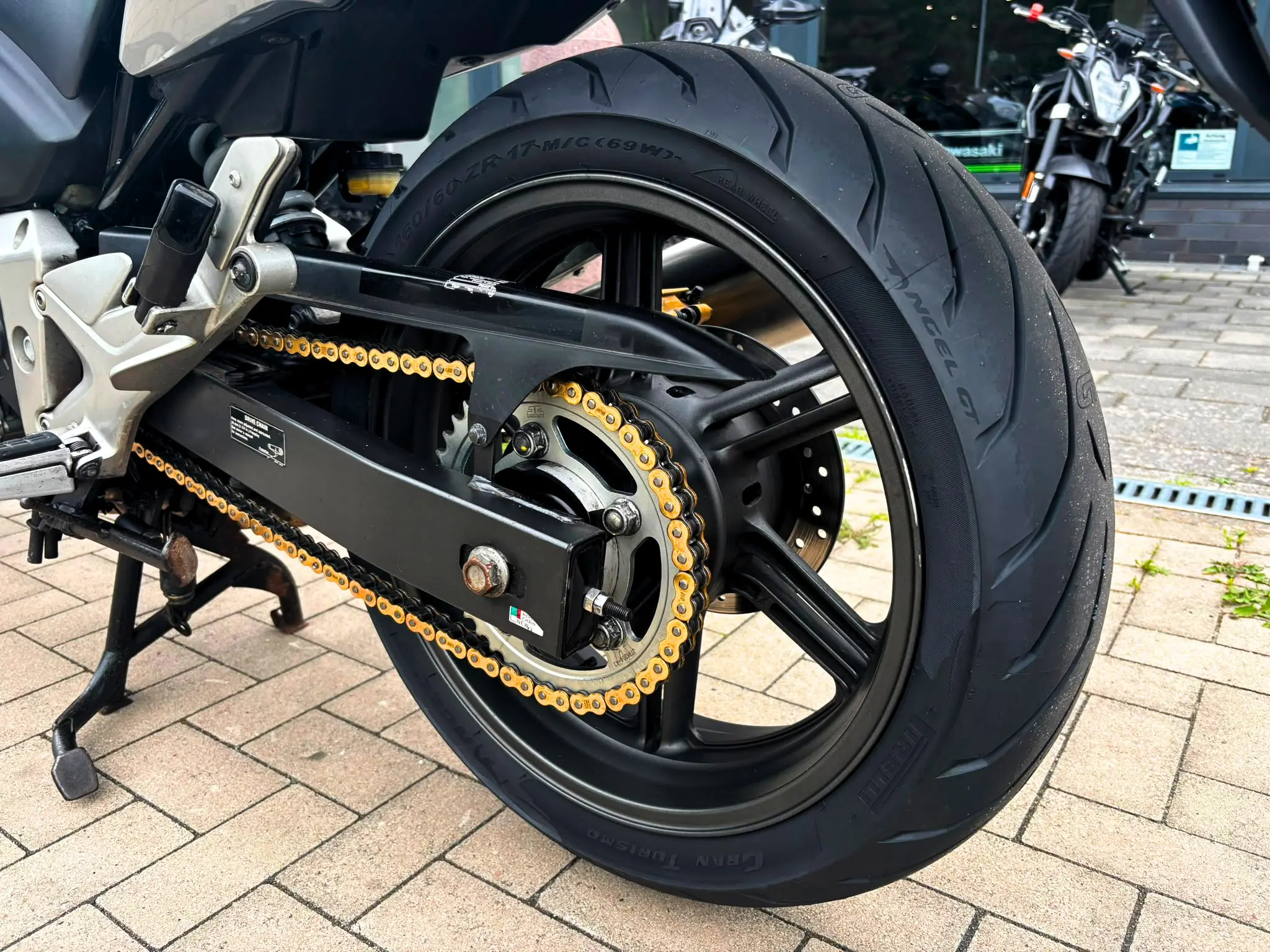 Nahaufnahme der goldenen Antriebskette und des Hinterrads einer Honda CBF 600 SA ABS nach professioneller Aufbereitung bei BikeTech Lohmann in Walsrode.