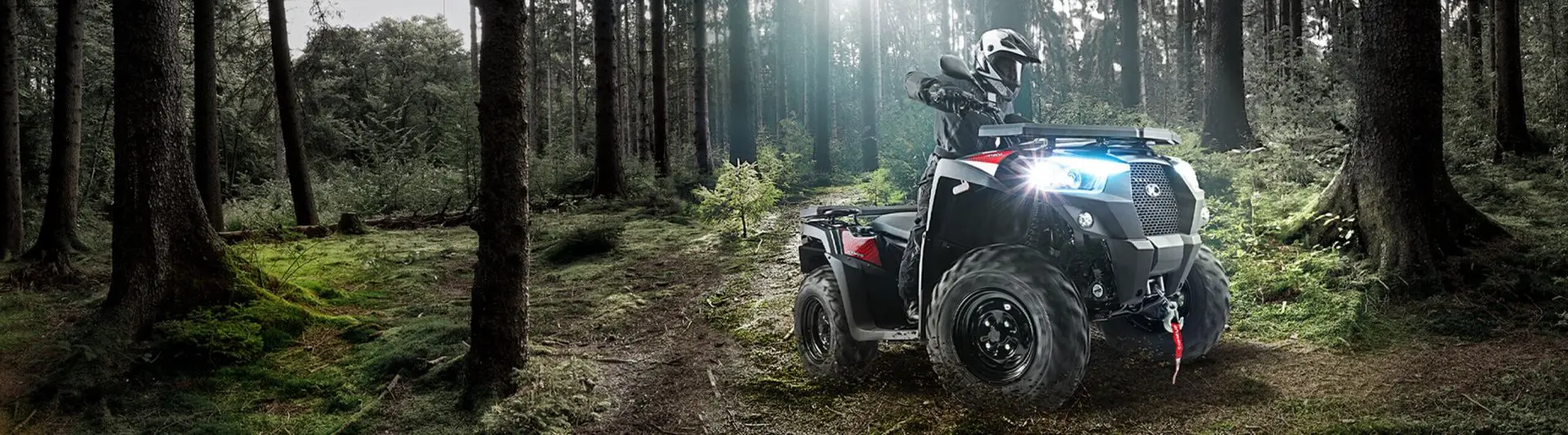 Kymco ATV im Gelaendeeinsatz auf Waldweg, Fahrer beschleunigt mit Allradantrieb bei BikeTech Lohmann Walsrode