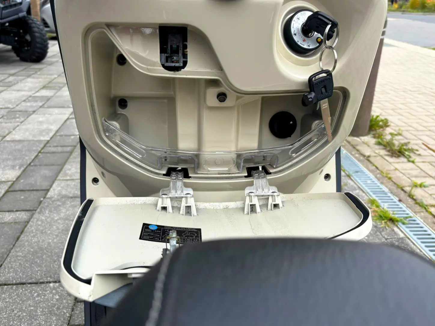 Geöffnetes vorderes Ablagefach der Kymco Like 125 mit Zündschloss und zusätzlichem Stauraum
