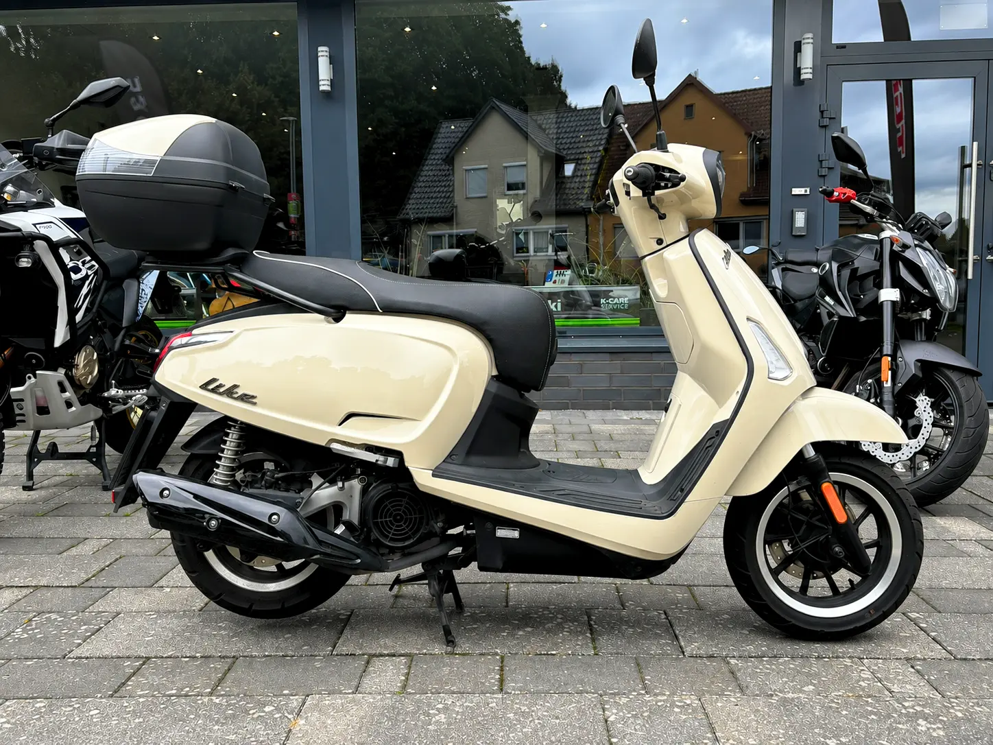 Kymco Like 125 Roller in Beige mit Topcase in Seitenansicht bei BikeTech Lohmann in Walsrode