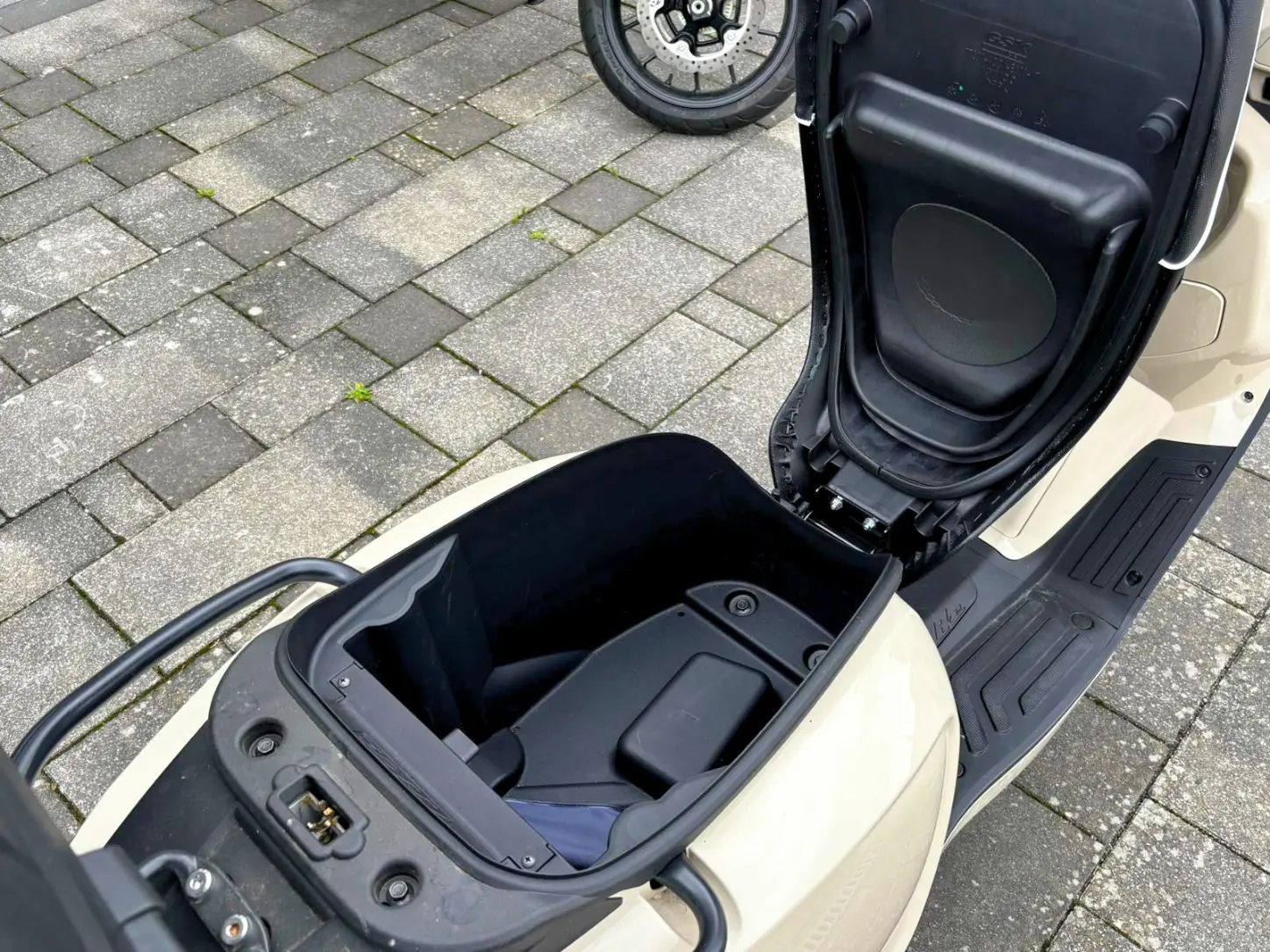 Geöffnetes Staufach unter der Sitzbank der Kymco Like 125 mit geräumigem Helmfach